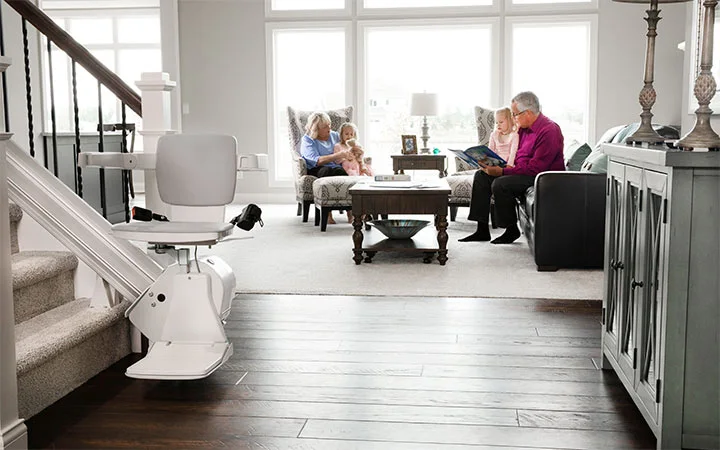 elan straight indoor stair lift with family sitting in the living room behind it