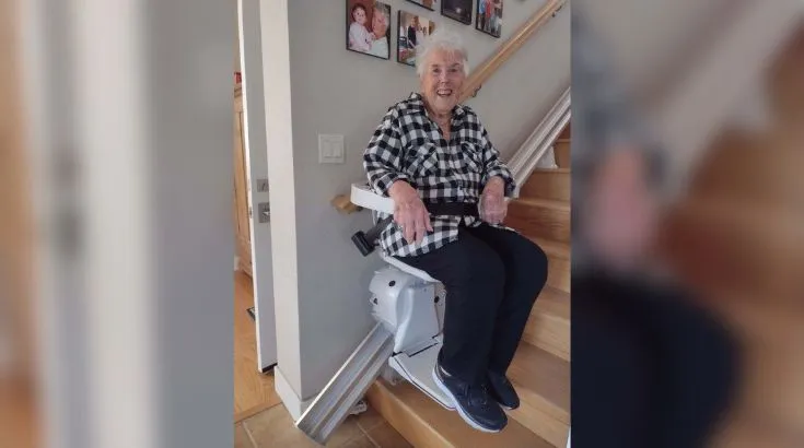 a woman riding an indoor stair lift